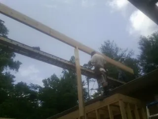 Carpenter setting a ridge beam over a new addition frame — Ice Dam Removal by Roofing Brothers in Mount Angel