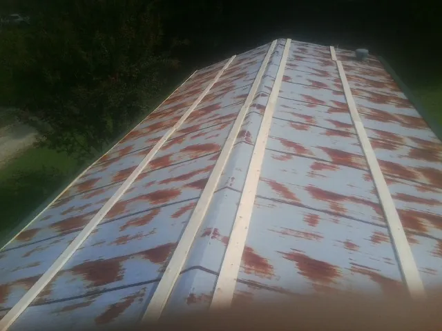 Rusted metal roof panels with new wood purlins before replacement — Storm Damage Roof Repair in Mount Angel by Roofing Brothers