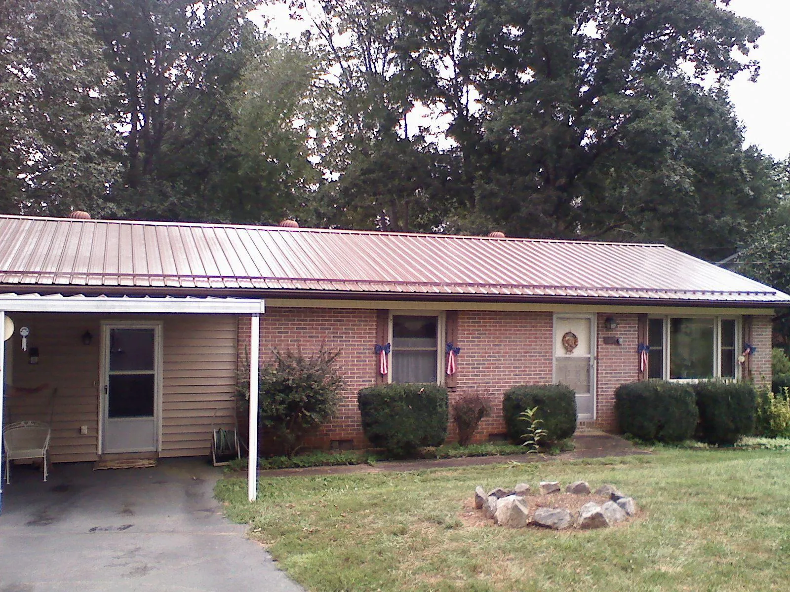 Bronze metal roof and carport on a brick ranch home — Roof Repair work by our crew in Mount Angel